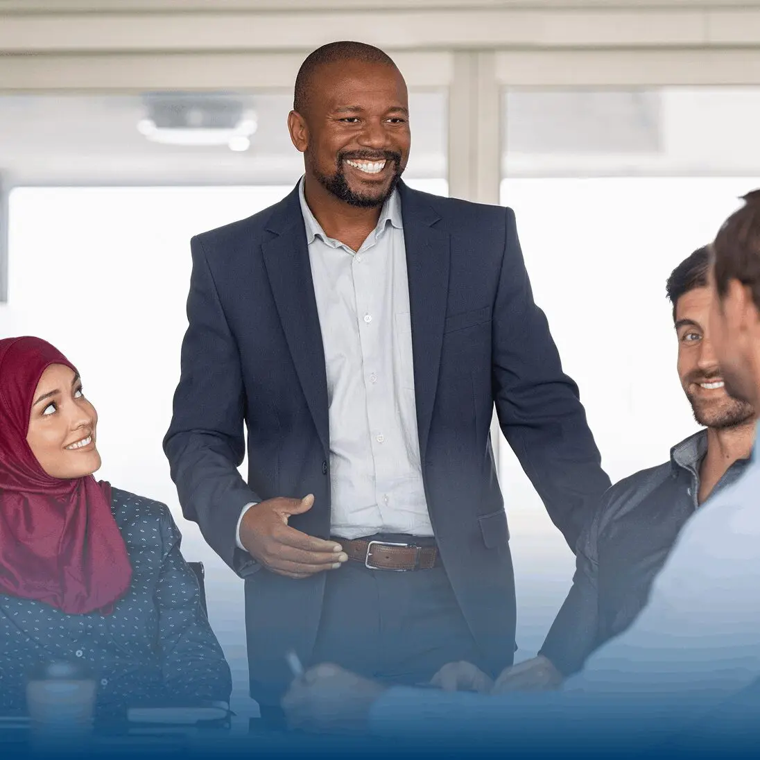 A diverse group in a meeting, smiling and engaging.